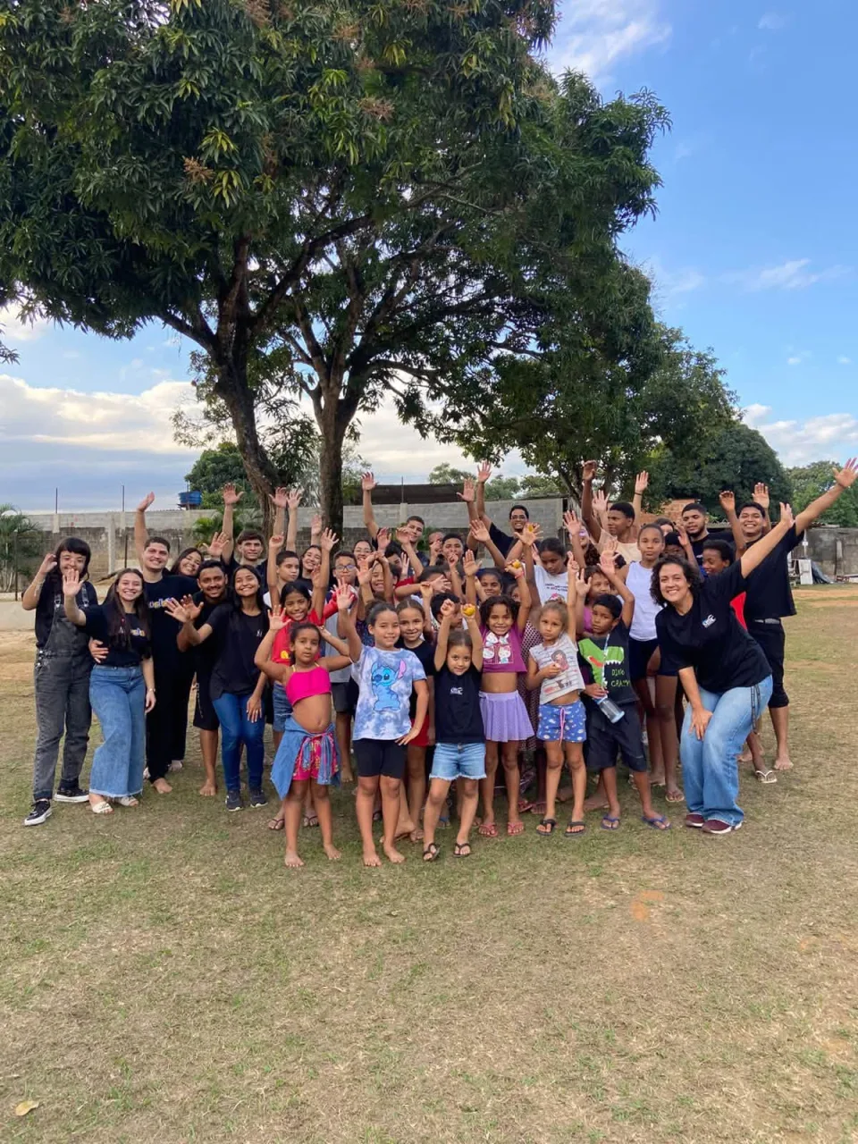 Children and MIRC Brasil team members gathered outdoors after a youth program